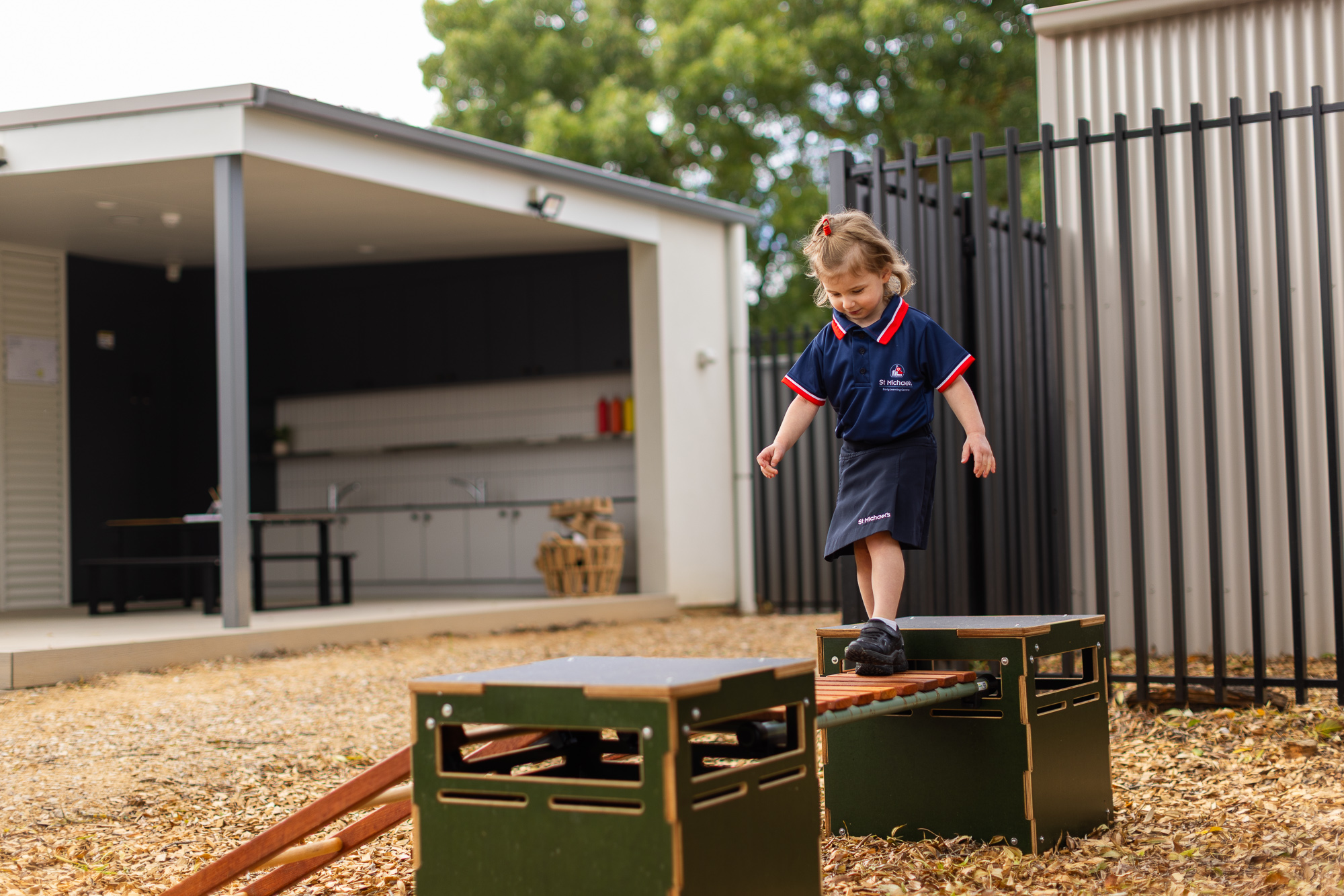 **Alt text:** Child balancing across outdoor play equipment at St Michael’s Lutheran Early Learning Centre.