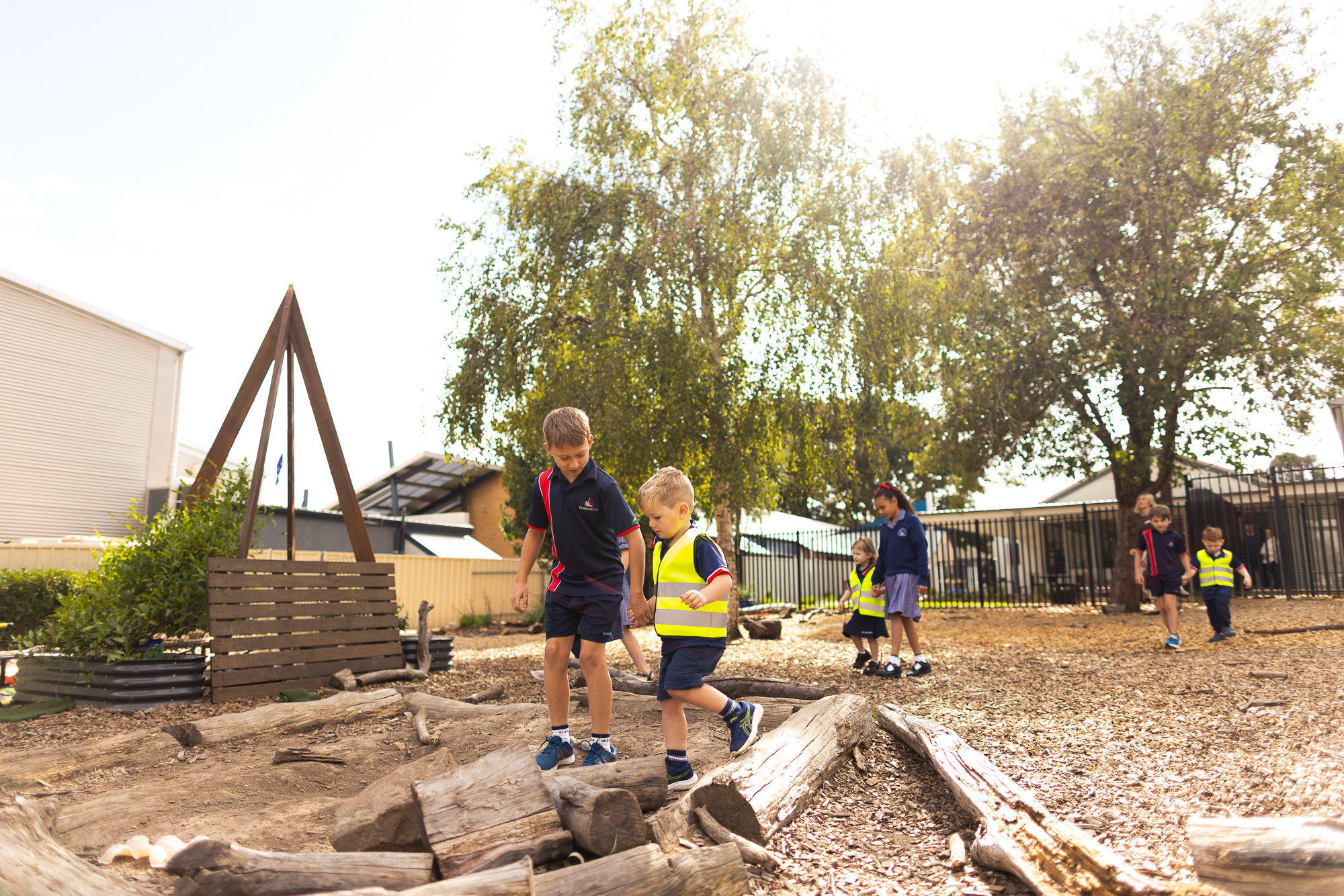 Children exploring an outdoor nature play area at St Michael’s Early Learning Centre.