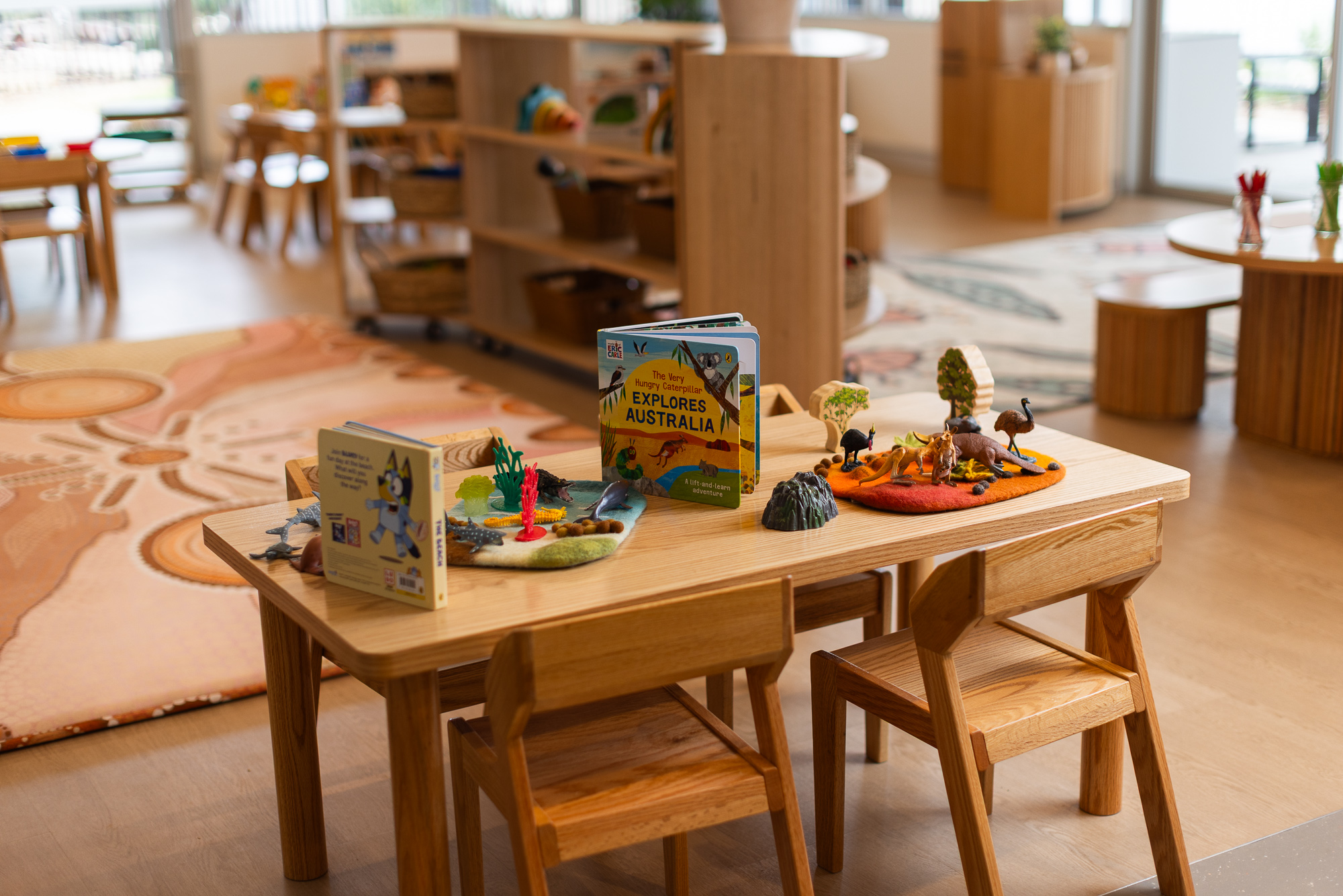 Children’s activity table with books and Australian animal-themed learning materials in an early learning classroom