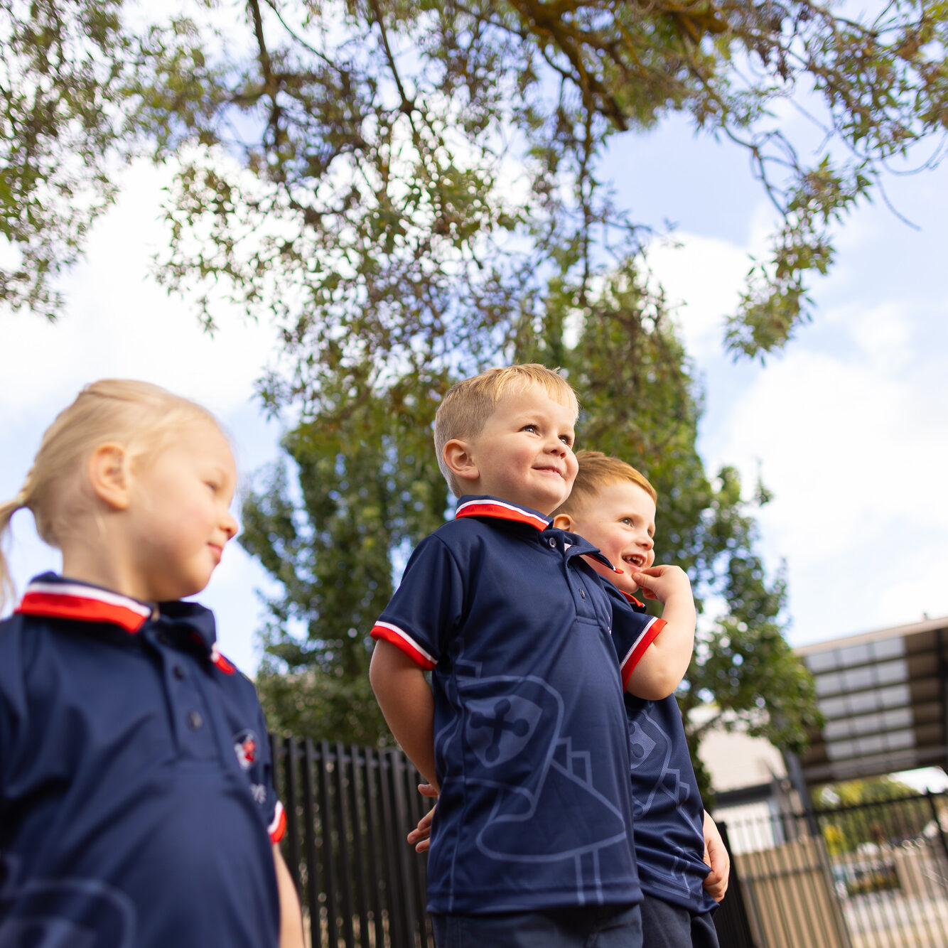 Children in St Michael’s school uniforms enjoying outdoor play at an early learning centre.