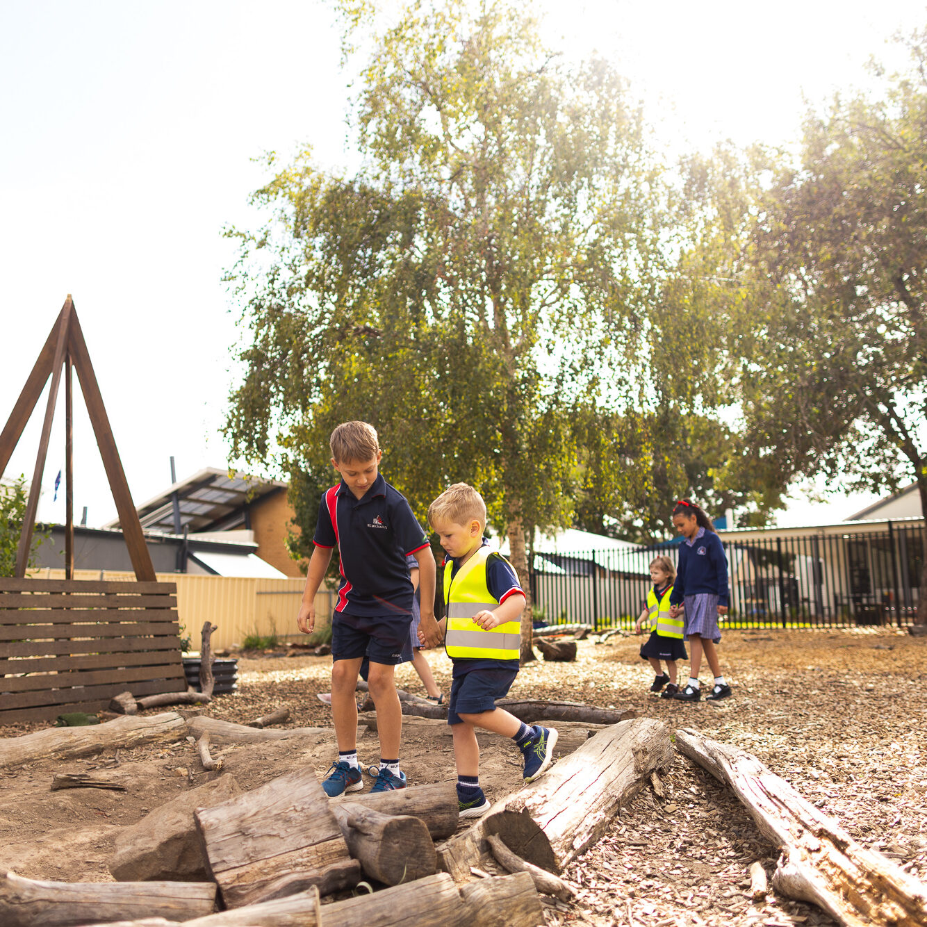 Children exploring an outdoor nature play area at St Michael’s Early Learning Centre.